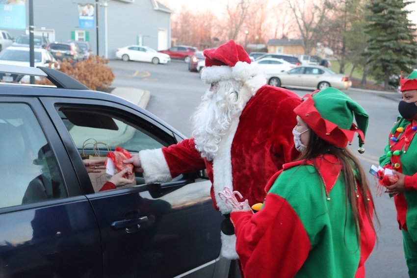 Santa and his elves distribute a holiday meal and treats at New Hope Community.